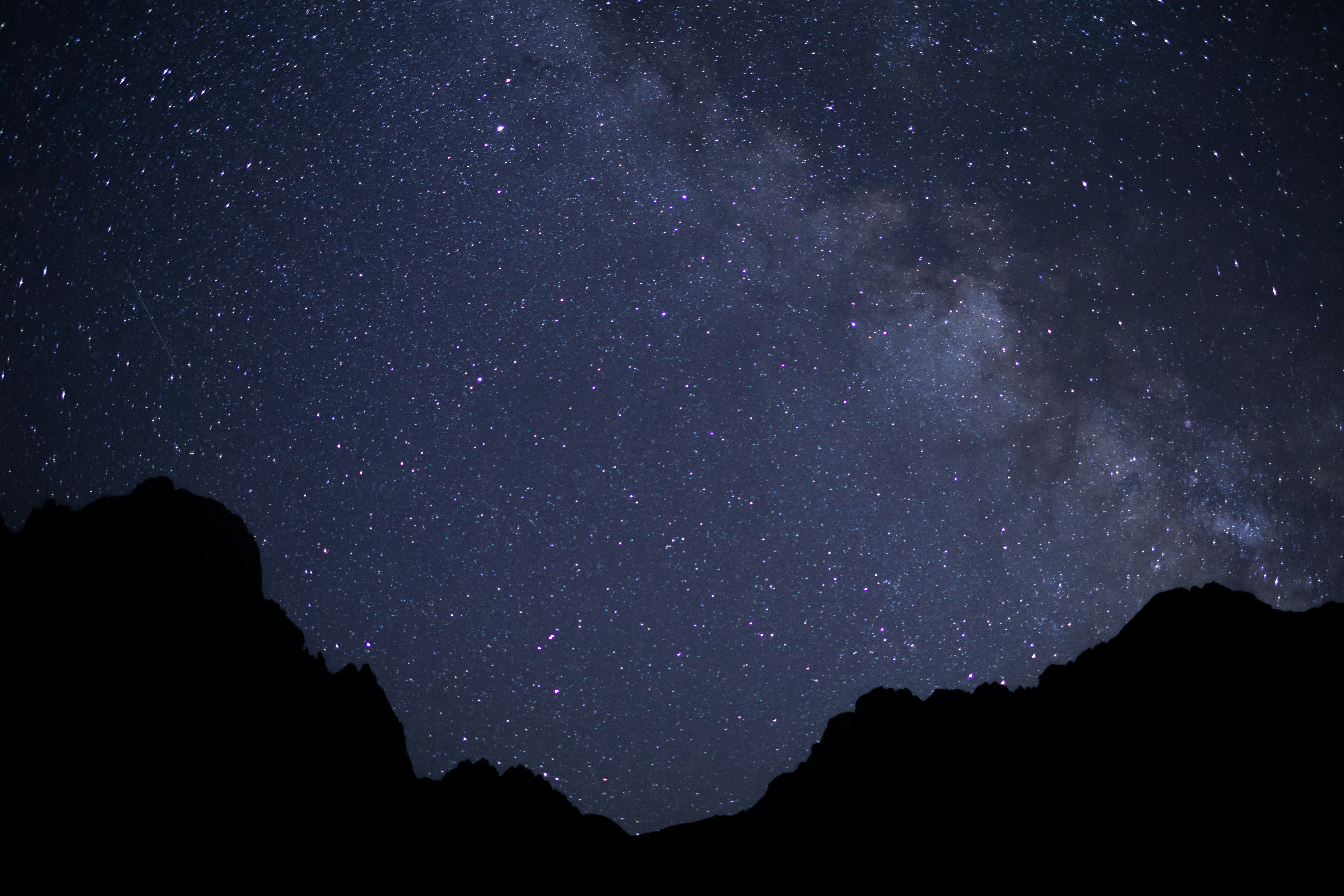 silhouette of mountain under starry night